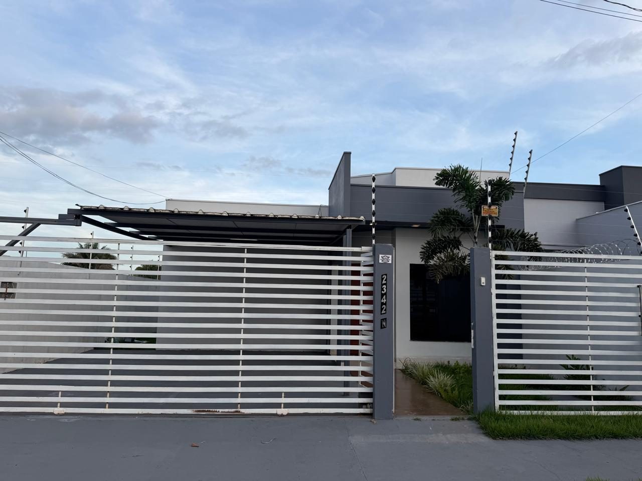 Fachada da casa com portão e garagem coberta